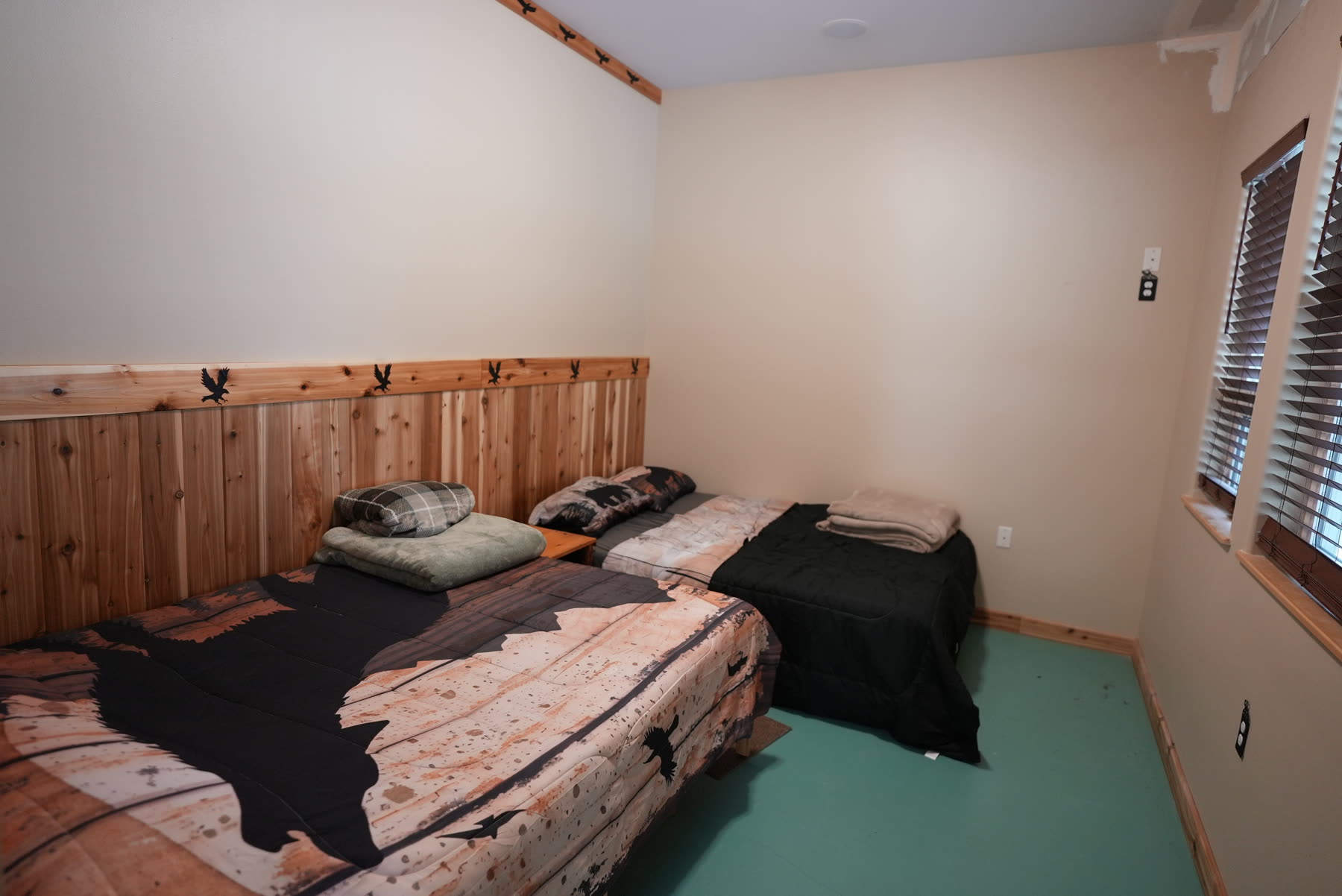 Bedroom with rustic wood walls and a bear-print bedspread