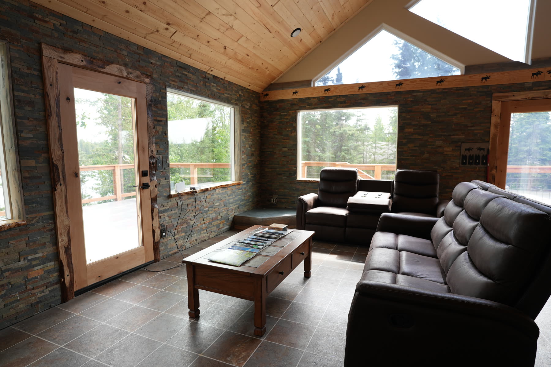 Great room with vaulted pine ceiling, big windows and leather seating