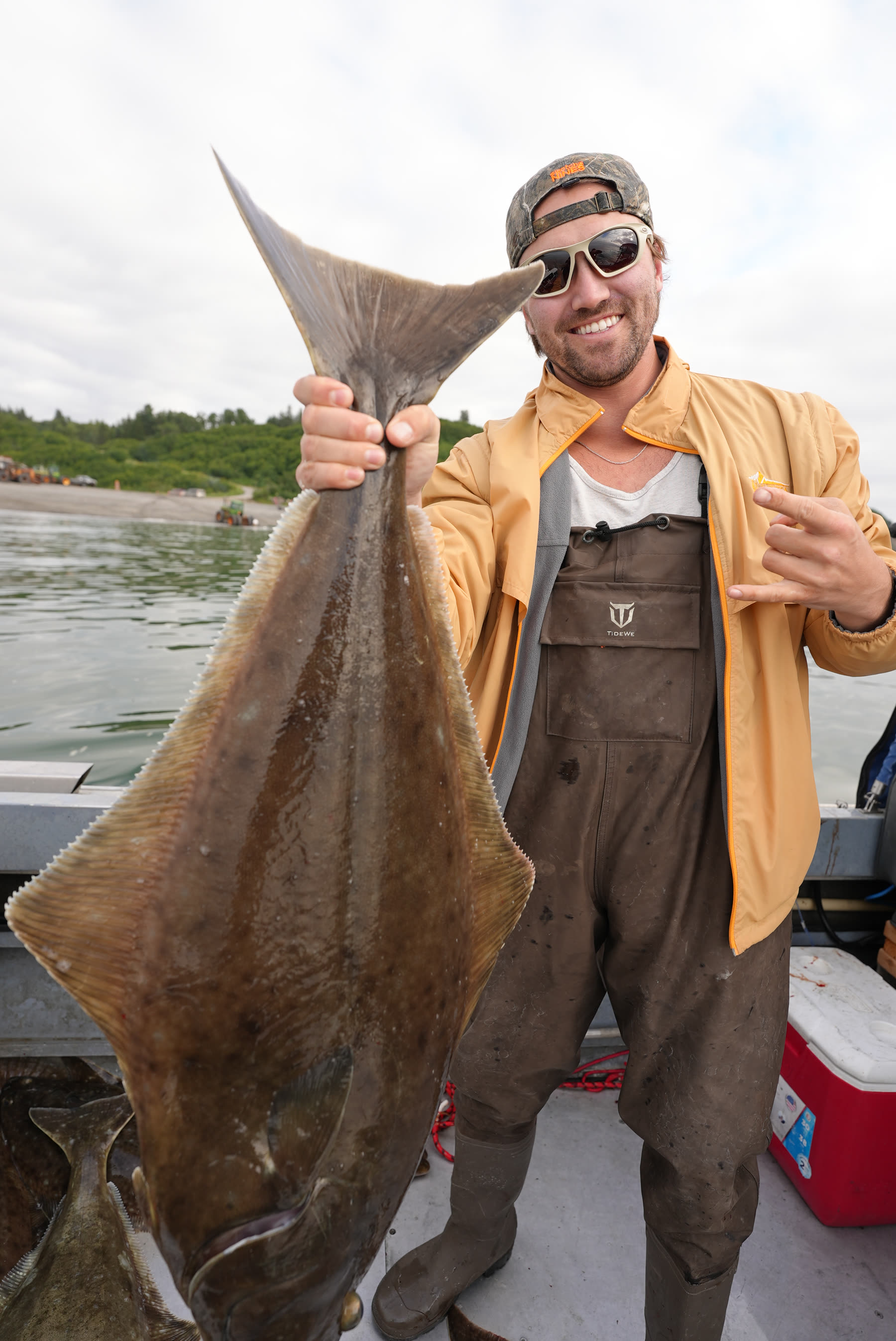Guest holding a large halibut on a boat